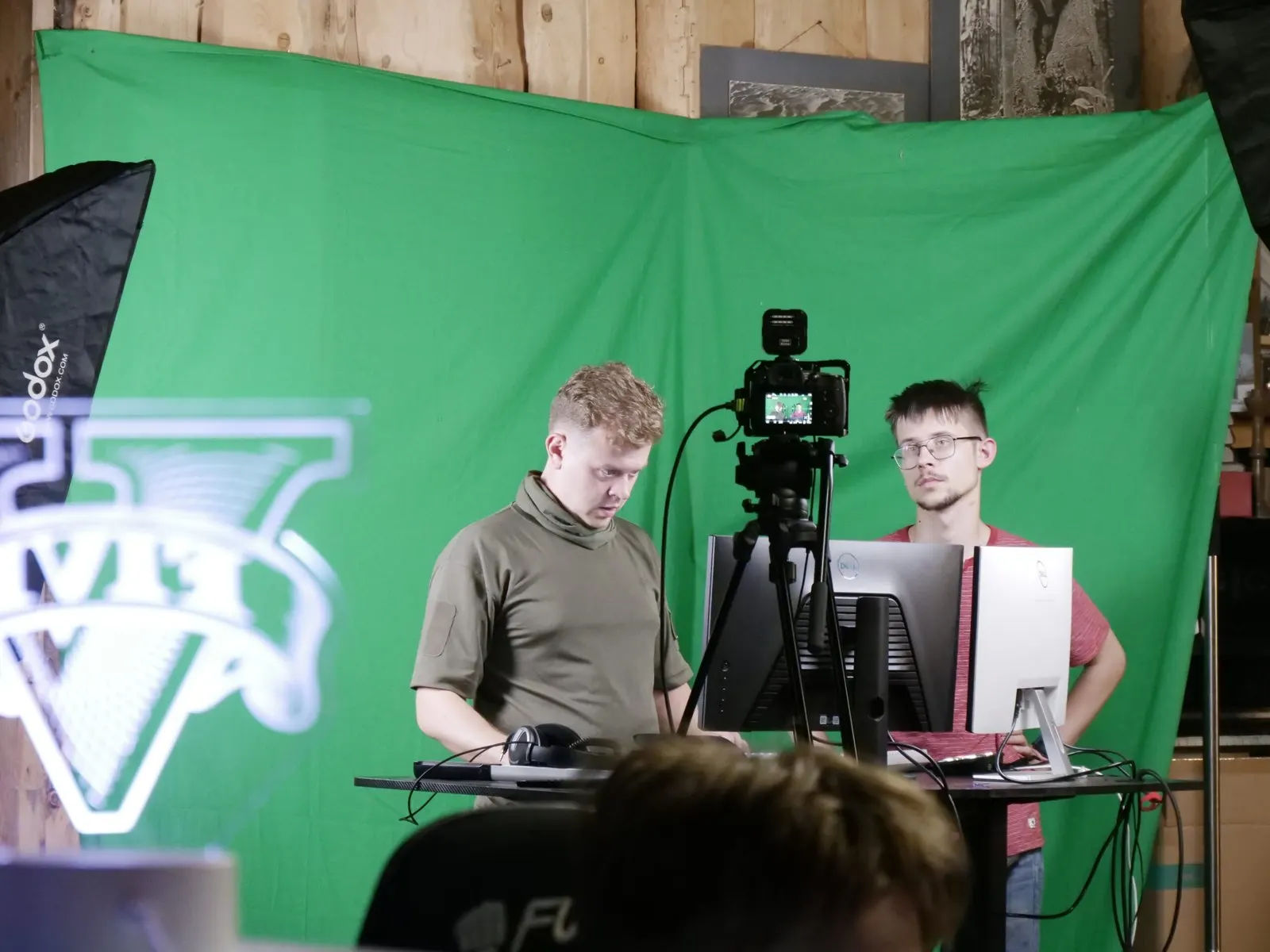 Vadovai filmuoja prieš žalią foną stovyklos studijoje